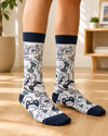 Pair of white and navy Arabic Gamer Crew Socks featuring colorful video game controllers and Arabic gaming-themed text on a white background.