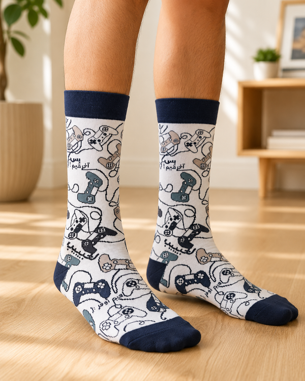 Pair of white and navy Arabic Gamer Crew Socks featuring colorful video game controllers and Arabic gaming-themed text on a white background.