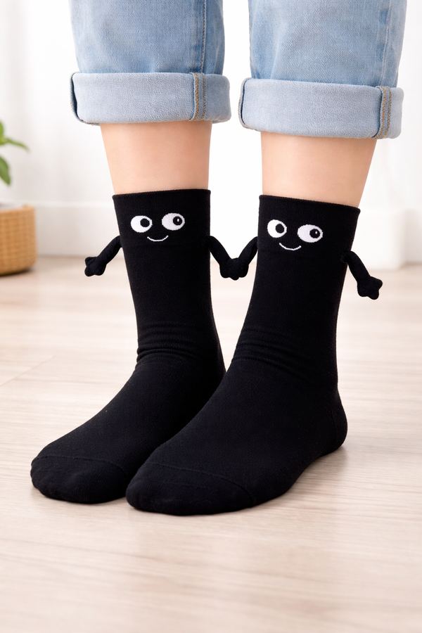 Black Magnetic Hug crew socks with smiling cartoon face and playful hugging arm design