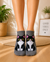 Grey ankle socks featuring a cute black and white tuxedo cat with yellow eyes and pink ears