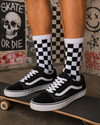 Black and white checkerboard pattern crew socks with retro skate-style design.
