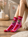 Pink cartoon inspired crew socks featuring animated girl artwork with bold red and pink details
