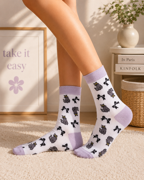 White crew socks featuring cute grey cat illustrations with black ribbon bow pattern design.