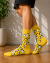Bright yellow crew socks featuring an all-over pattern of cute black and white penguins.