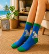 Blue crew socks with cute white cat design and green accents