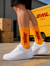 Bright orange crew socks featuring a delivery-inspired graphic design on the leg.