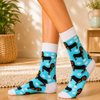 Turquoise crew socks with black and brown dachshund dogs, white paw prints and white accents
