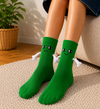 Green magnetic hug socks with smiling cartoon faces and connected plush arms
