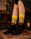Yellow and black crew socks featuring a cute wizard-inspired cartoon character with blonde hair and a red-yellow striped scarf in a magical school themed design.
