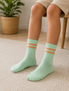 Kids wearing mint green crew socks with peach double stripes, designed for children aged 7–9 years.