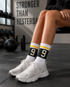 White athletic crew socks with black Number 9 varsity design and yellow stripes
