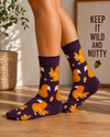 Purple crew socks featuring orange squirrels, acorns, and mushroom patterns.