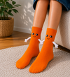 Orange novelty magnetic socks with smiling face and hugging arms