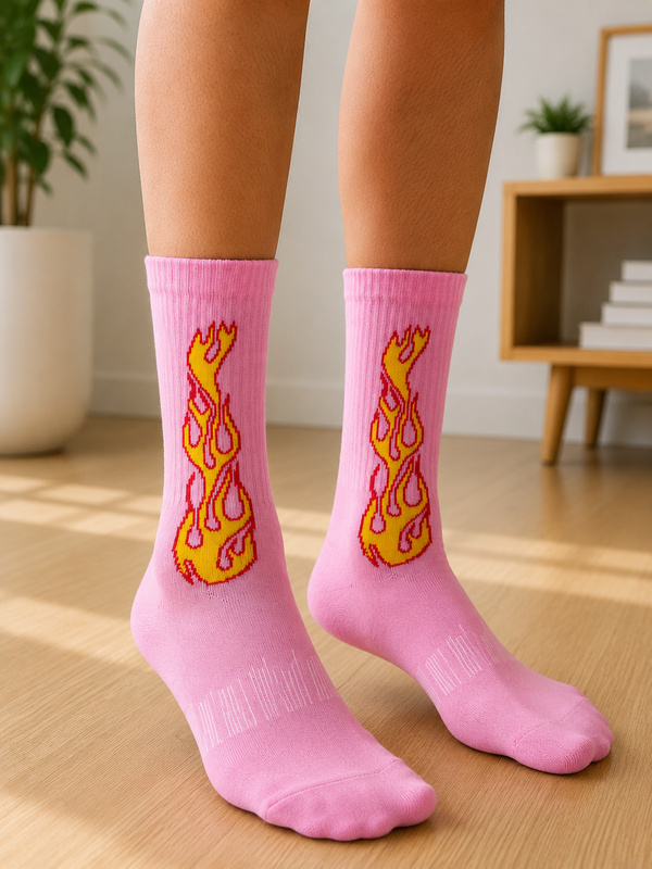 Pair of pink crew socks featuring a yellow and red flame graphic on the side, displayed on a white background.