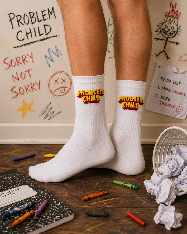 White crew socks with colorful Problem Child text graphic embroidered near the top.