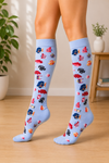 Light blue knee-high socks featuring colorful tropical fish pattern