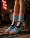 Cute penguin ice skating socks with pink scarf and heart pattern on pastel blue background