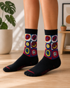 Black crew socks with colorful abstract circle artwork in red, yellow, blue and green