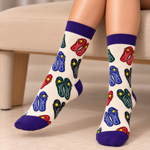 Bahraini Na'al Socks featuring colorful traditional Bahraini slipper patterns in red, blue, green and black on a cream background with purple cuffs and toes.