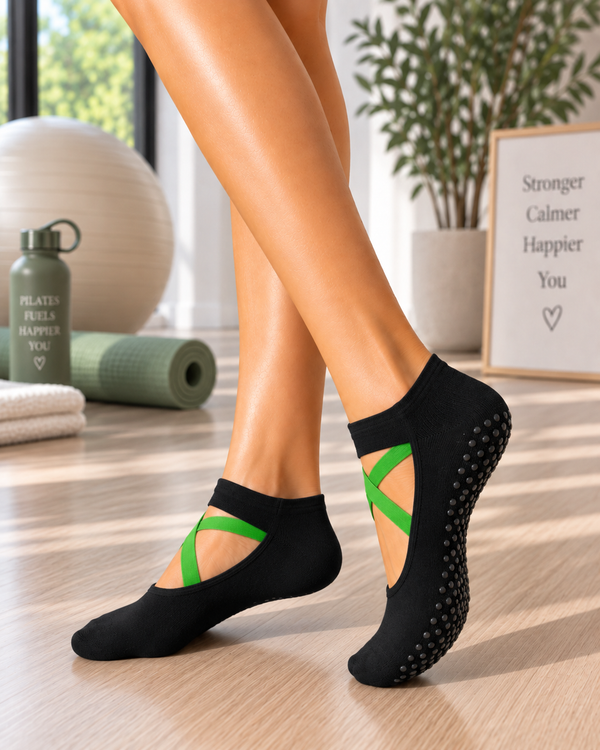 Black Pilates grip socks with green crossover straps