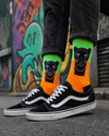 Bright green and orange crew socks featuring a stylish black panther character with gold chain details in a bold urban-inspired design.