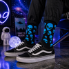 Black crew socks featuring multiple blue alien head graphics with green eyes in a fun extraterrestrial-inspired pattern.