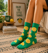 Green crew socks with orange citrus slice patterns and colorful fruit themed design.
