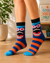 Blue and orange crew socks featuring a funny cartoon face with pink sunglasses and a large open mouth