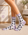 White crew socks featuring cute grey cat illustrations with black ribbon bow pattern design.