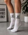 White crew socks with the embroidered phrase "Cute But Psycho" in black lettering.