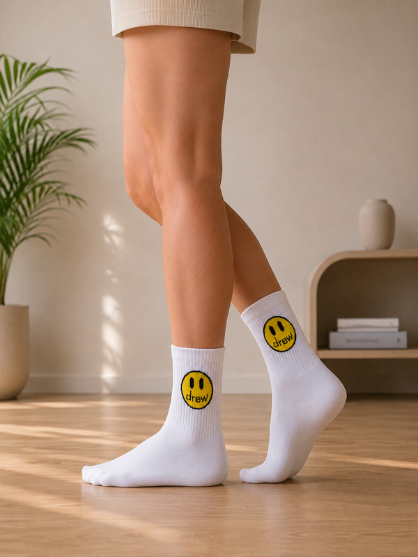White crew socks with yellow smiley face and drew graphic design
