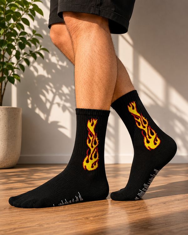 Black crew socks featuring bold yellow and red flame graphics on the leg.