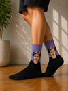Black crew socks featuring a Frida Kahlo portrait design on a lavender background.