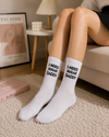 White crew socks featuring bold black “I NEED SUGAR DADDY” text in a minimalist statement-style design.