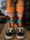 Peach-orange crew socks featuring a colorful iced coffee cup with whipped cream and dessert-inspired graphics in blue, brown, white, and mint green tones.