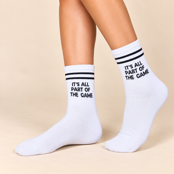 White crew socks with black stripes and It’s All Part of the Game slogan