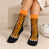 Orange and black crew socks featuring spotted leopard legs with detailed white claws