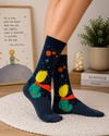 Dark galaxy-themed crew socks featuring a little prince inspired character sitting under stars