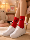 Red Magnetic Hug crew socks with smiling cartoon face and soft hugging arm design
