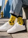 Yellow socks with dark navy cuff and toe featuring all-over Minion-inspired character pattern