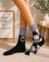 Black and white mystic cat crew socks with yellow eyes and playful cat pattern design