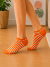 Orange ankle socks with white striped pattern for men and women.