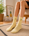 Pastel yellow crew socks with small pineapple embroidery design.