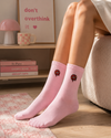 Pink crew socks with colorful donut embroidery design