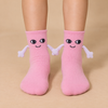 Pink kids socks with cute smiling faces and magnetic hands