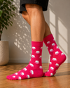 Bright pink crew socks featuring an all-over pattern of cute white sheep faces.