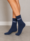 Navy blue crew socks featuring white Problem statement text