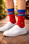 Red crew socks with blue cuff, Arabic text, and small shrimp-inspired pattern design
