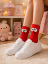 Red crew socks with fluffy googly eye cartoon design for casual unisex wear