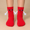 Red kids socks with cute smiling faces and magnetic connecting hands